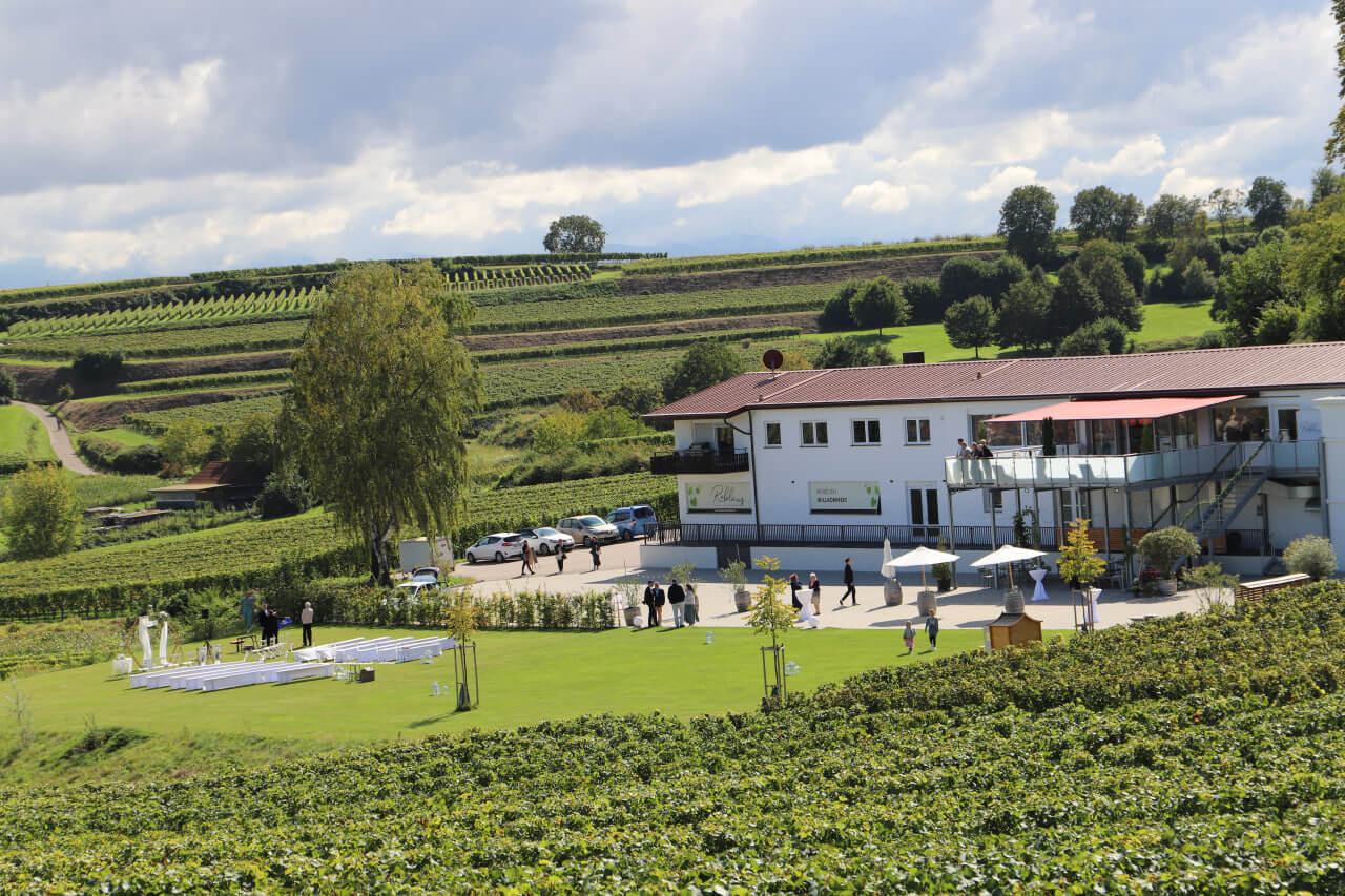 Die Reblaus: weißes Haus mit Terrasse und Wiese für die freie Trauung, umgeben von Weinbergen